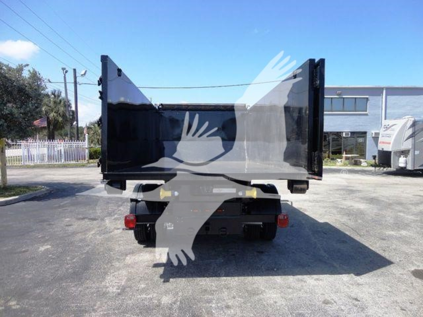 Ram 5500 HD roll-off truck rear view showing cargo bed open with tailgate raised, lights, and hitch area visible.