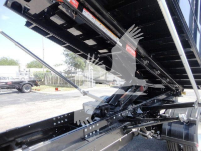 Ram 5500 HD roll-off truck bed mechanism showing hydraulic supports and metal frame with warning labels visible.
