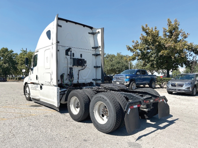 Freightliner Cascadia126 sleeper cab with rear wheel setup and side exhaust, showing chassis and tractor-trailer configuration in a lot.