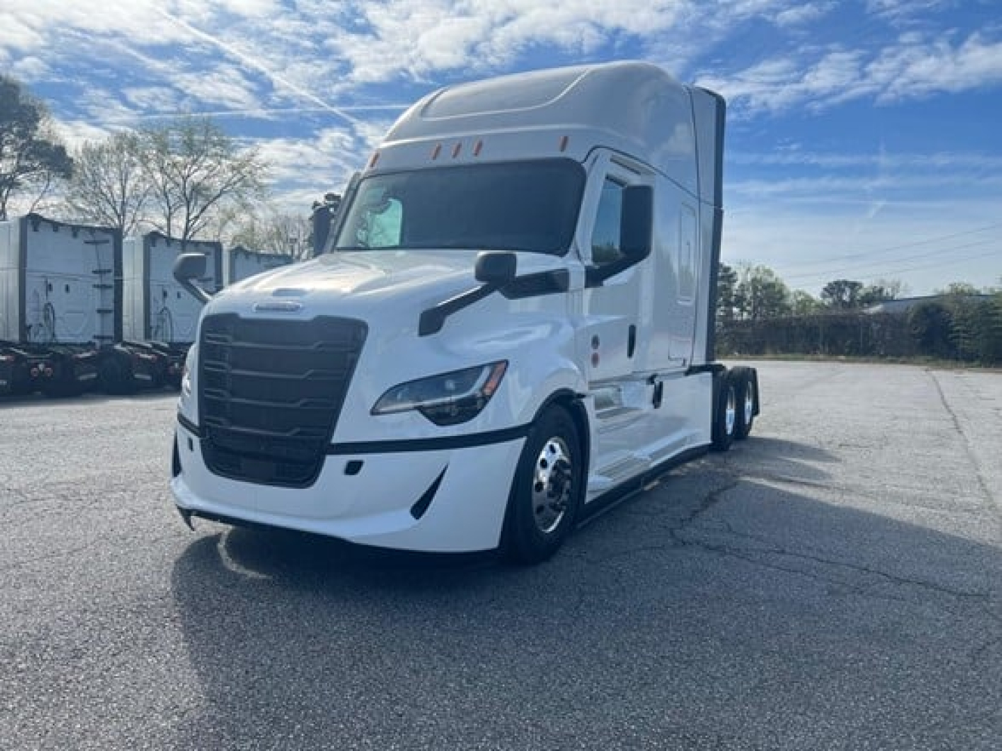 Truck cab front-left view showing a white Freightliner Cascadia 126 sleeper, with black grille, headlights, and side mirrors.