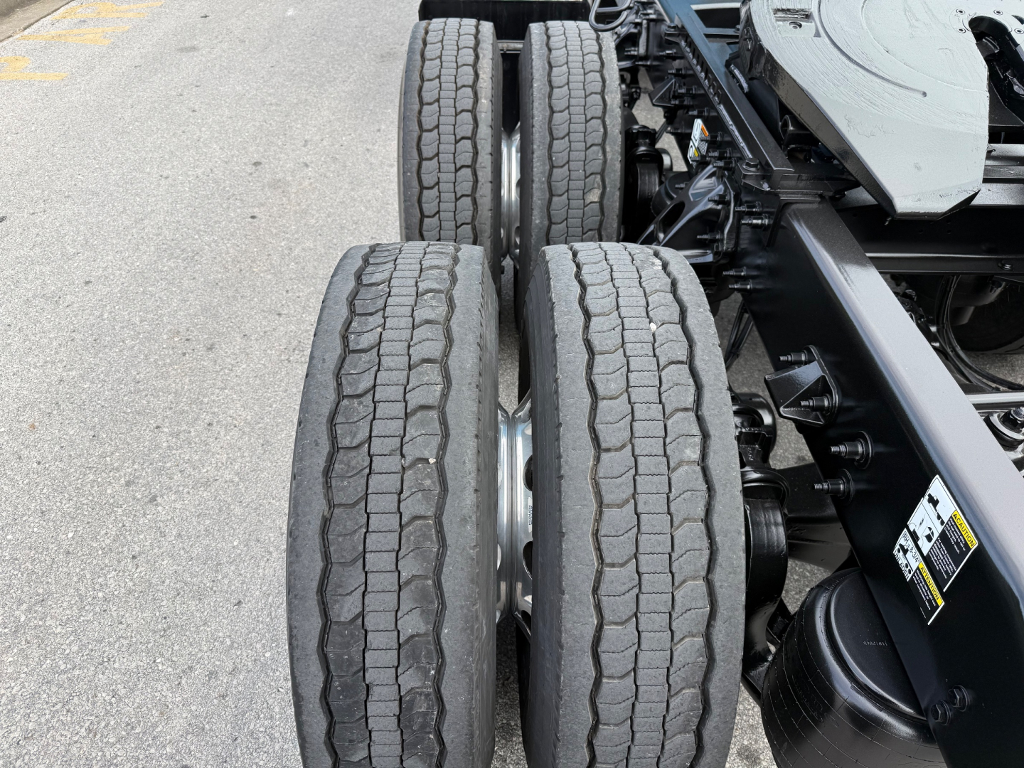 Truck rear dual-axle configuration showing tires and suspension undercarriage of a Peterbilt 579 chassis.