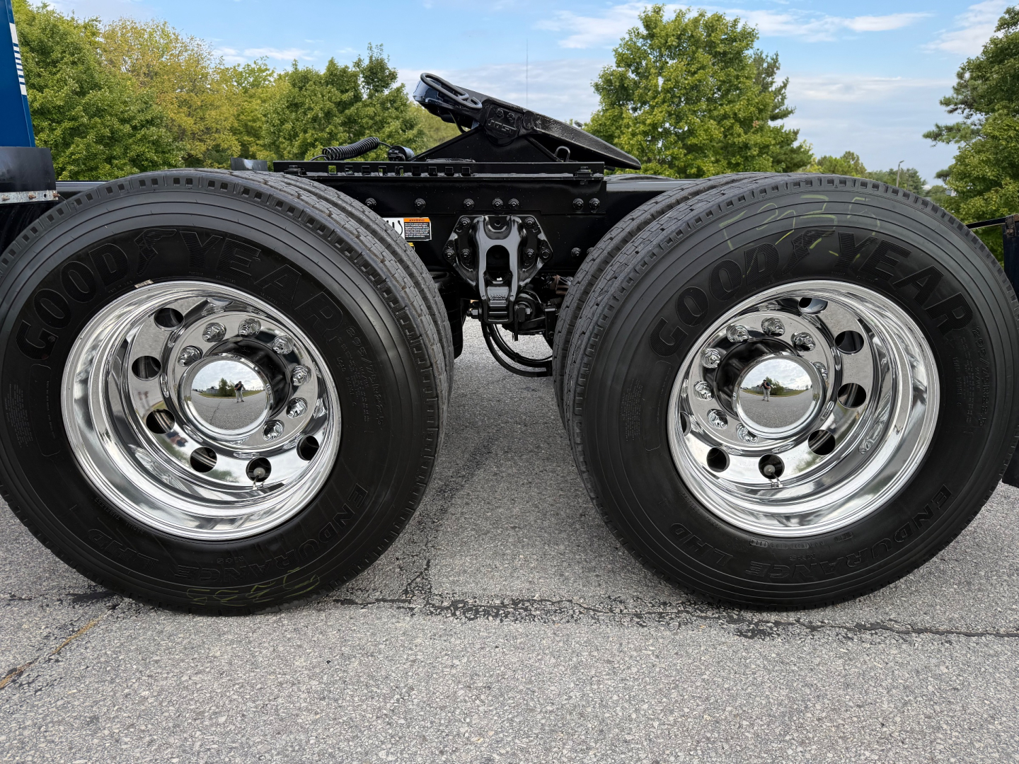 Peterbilt 579 truck chassis with dual rear wheels showing Goodyear tires and shiny chrome rims, undercarriage and frame visible.
