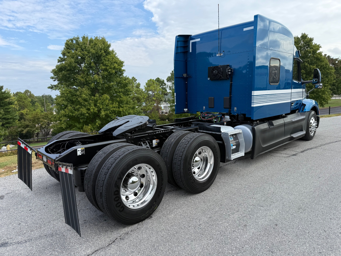 Peterbilt 579 tractor-trailer in blue seen from rear side showing sleeper cab and rear wheels