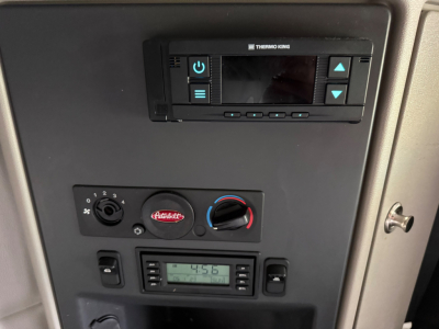 Peterbilt 579 dash area showing Thermo King unit, HVAC controls, and digital radio; presence of a small dash-mounted display and climate control knobs.