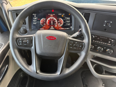 Peterbilt 579 steering wheel and dashboard view showing digital gauge cluster and center console controls.