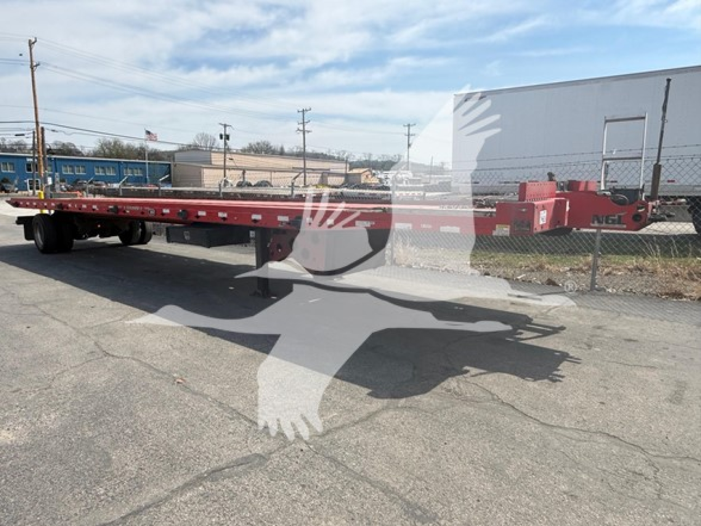 Landoll 343B trailer in a yard showing long red platform and hitch; side rails and deck; VIN 1LH343RG3J1A25555 not on visible label.