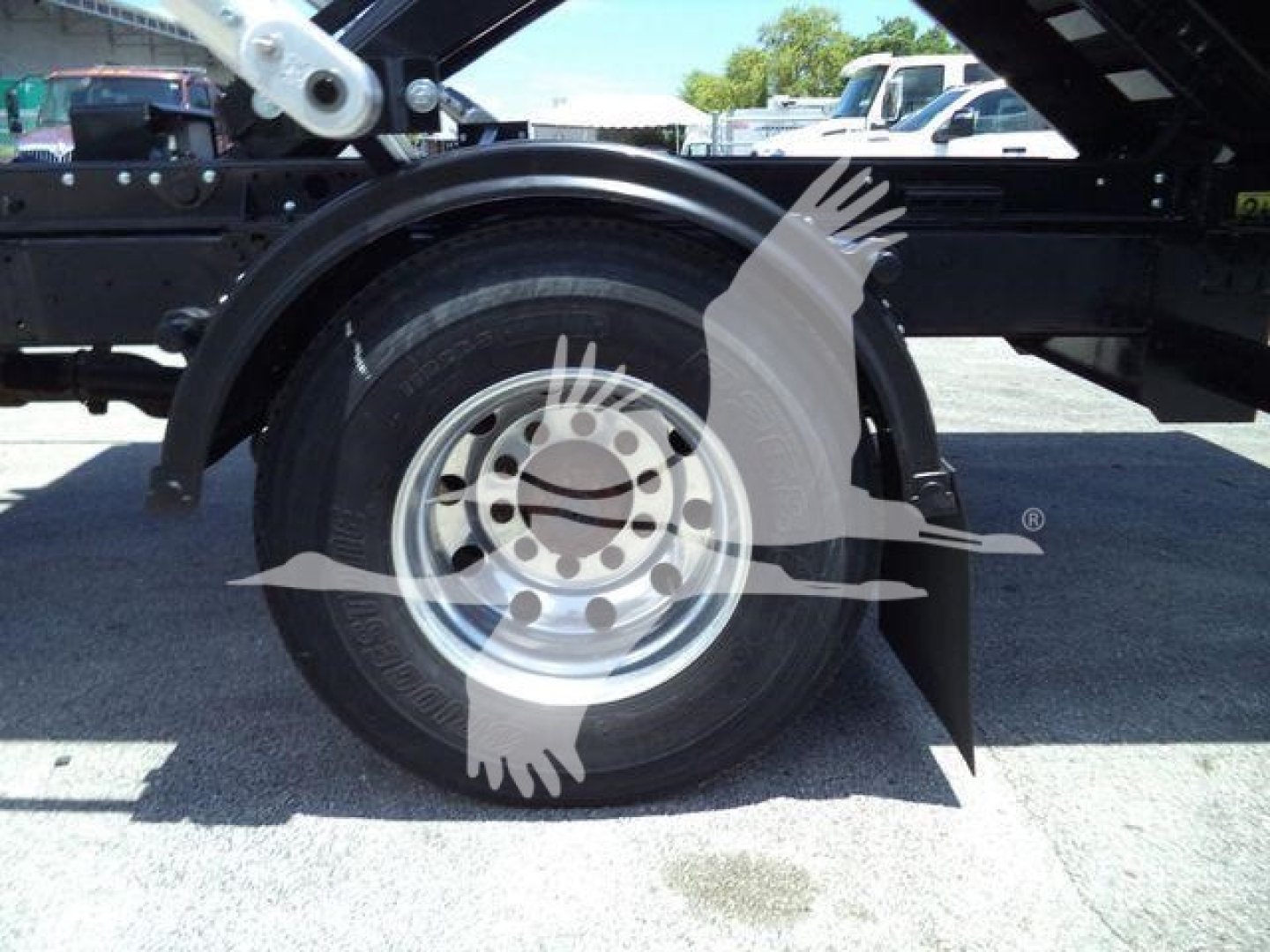Truck wheel and fender detail on a 2020 International MV roll-off chassis showing steel wheel and tire with surrounding components.