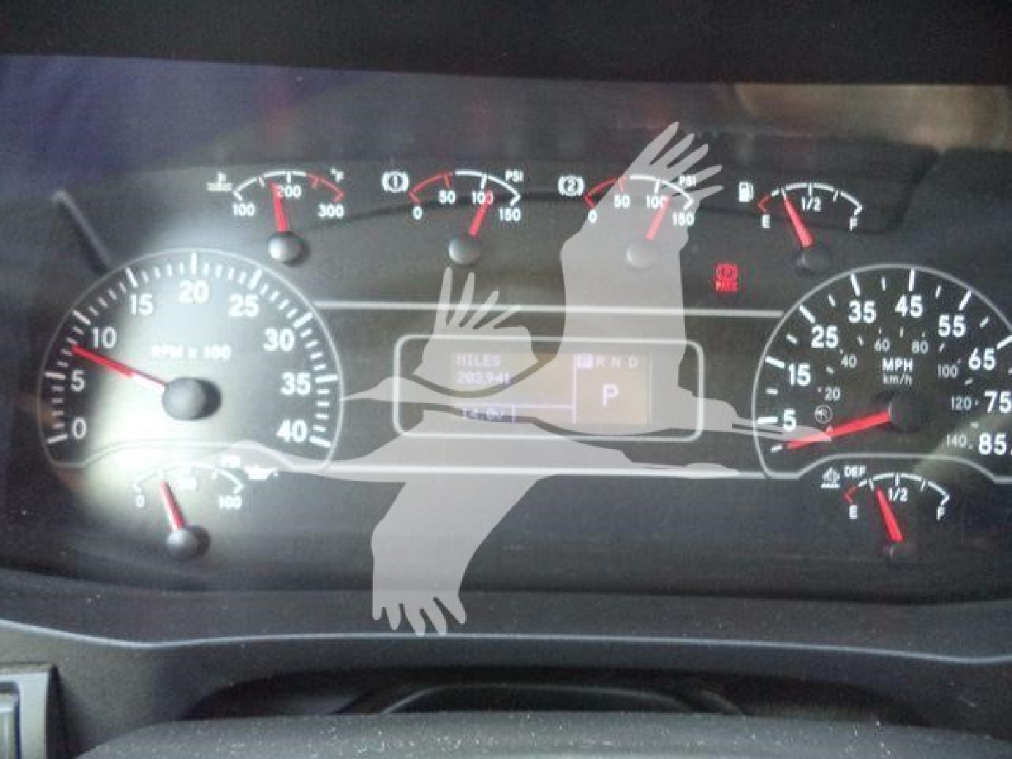 Cab dashboard of a 2020 International MV roll-off truck showing speedometer, tachometer, and warning lights with a central display and gear indicator.