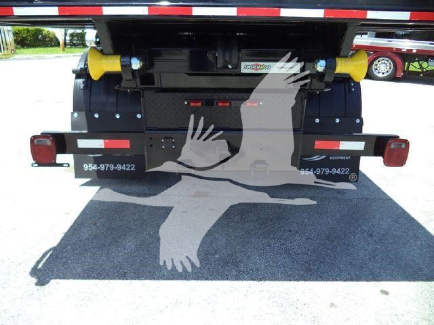 Rear view of a 2020 International MV roll-off truck showing yellow dual support rollers and taillights with stock number T80582.