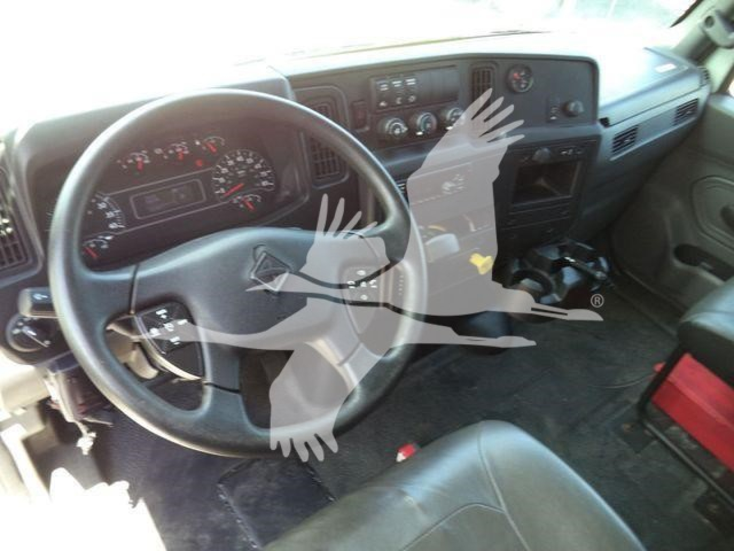 Dashboard and steering wheel of a used 2020 International MV roll-off truck interior showing steering wheel, instrument cluster, center console, and pedals.