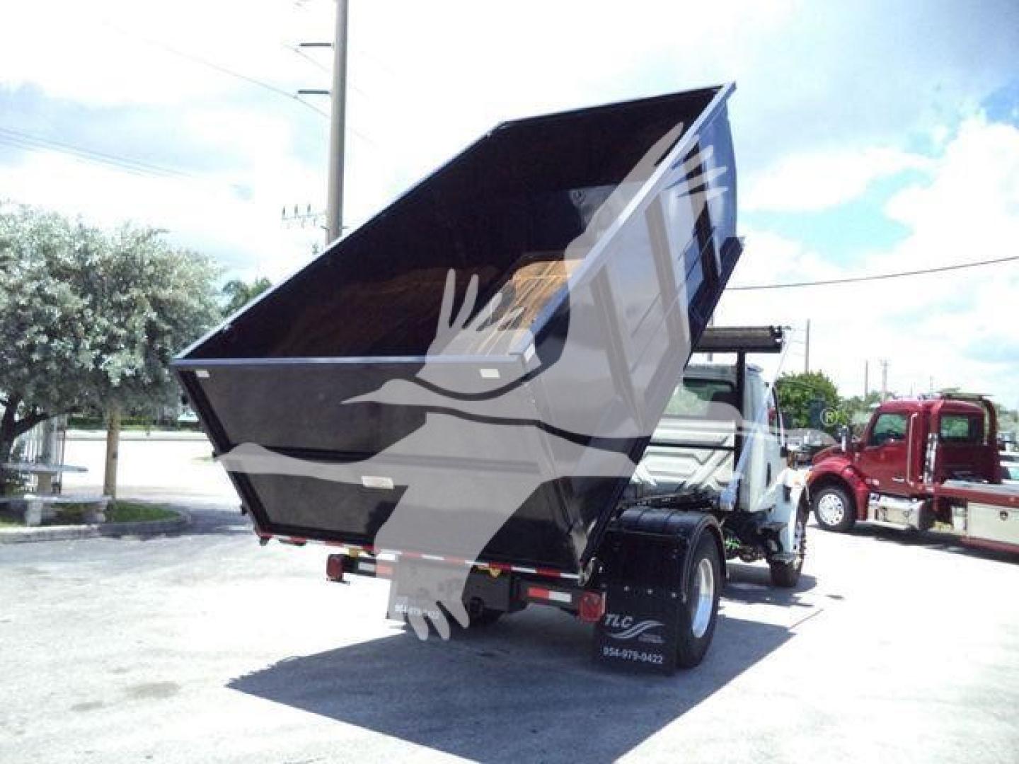 Truck bed in dump configuration showing raised dump body on a 2020 International MV rolloff truck.