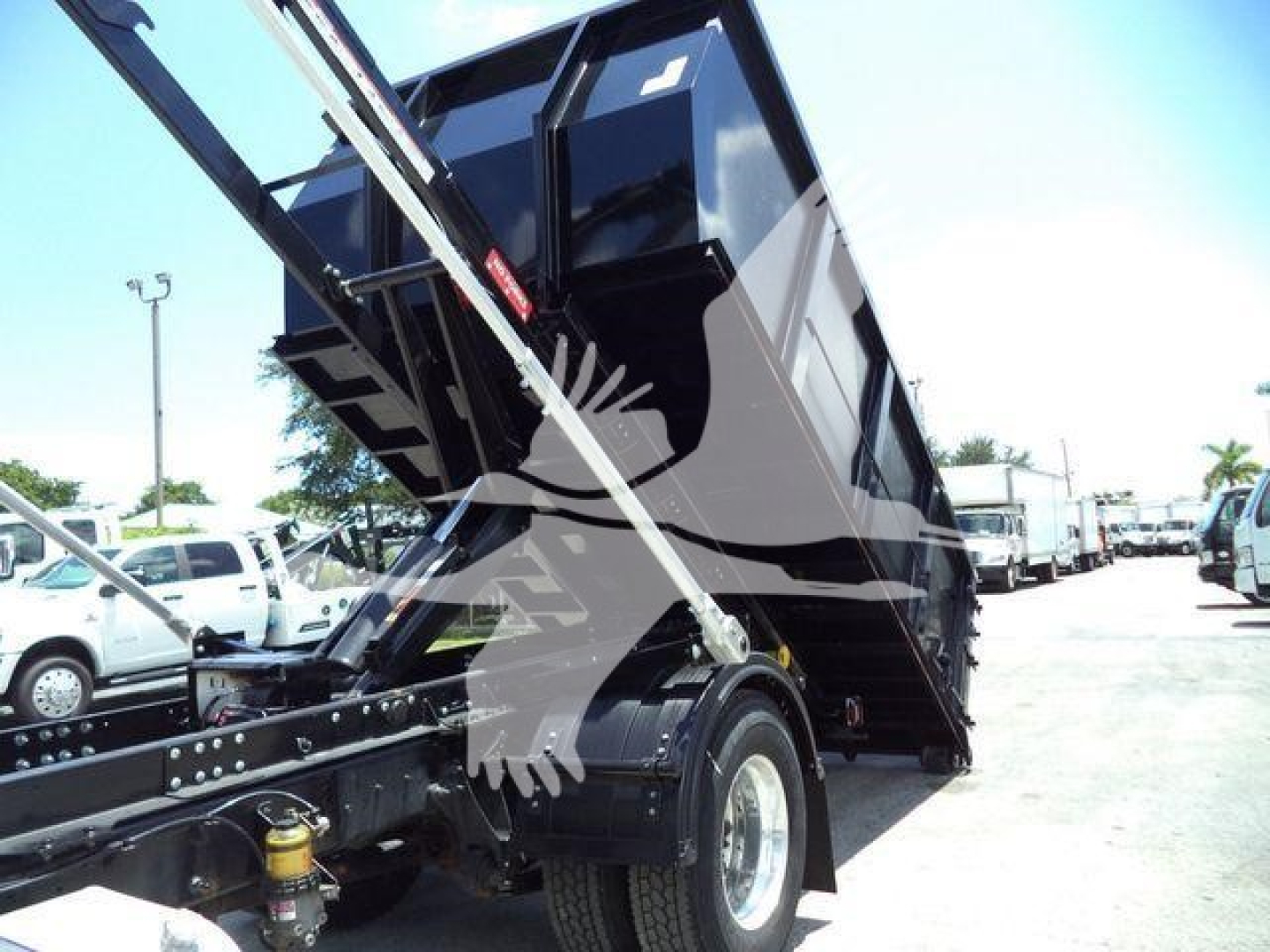 Rolloff truck bed in raised position showing hydraulic ram and chassis with rear wheel;International MV, stock number T80582, VIN 3HAEUMML6LL880582.