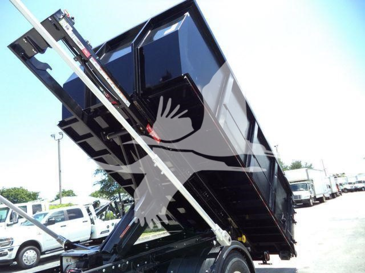 Dump truck bed in raised position showing hydraulic arms and cargo area with label-free view.
