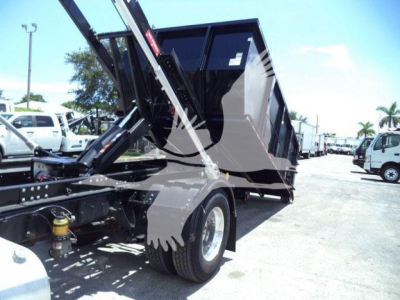 Truck chassis and dump bed of a 2020 International MV roll-off showing hydraulic mechanism and wheel.