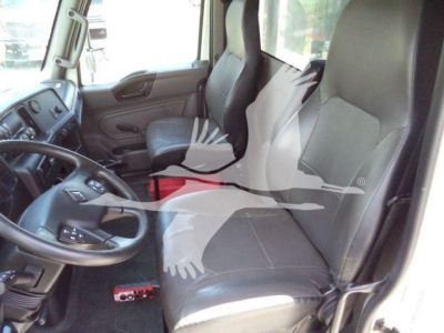 Interior of a 2020 International MV roll-off truck showing driver seat and front passenger seat with steering wheel and dashboard visible.