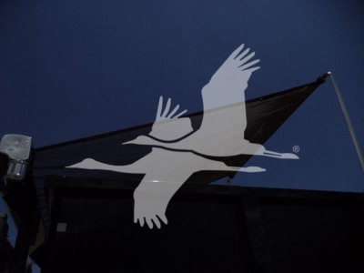 Truck cab area with dark blue sky and a white seagull logo overlay; no readable labels visible.