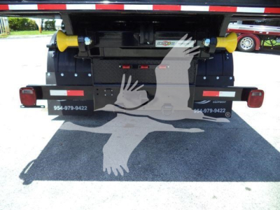 Rear view of a 2020 International MV roll-off truck showing yellow dual support rollers and taillights with stock number T80582.
