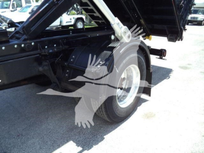 Truck chassis of a 2020 International MV roll-off showing rear wheel and hydraulic bed mechanism viewed from side.