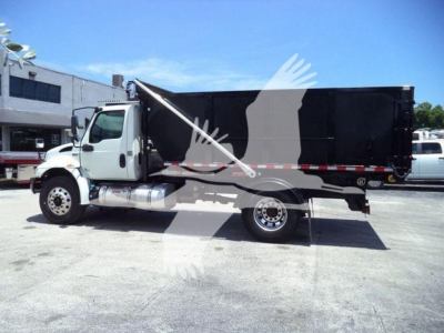 Truck side view of a 2020 International MV rolloff with black dump body, white cab, and dual rear wheels.
