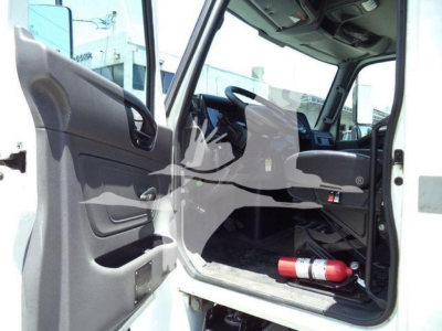Interior of a 2020 International MV rolloff truck cab showing open driver door, steering wheel, dashboard, and a red fire extinguisher on the floor.