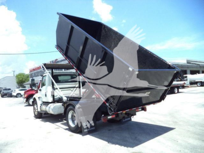 Dump truck in service with raised dump bed showing cargo area and hitch, International MV model, used vehicle.