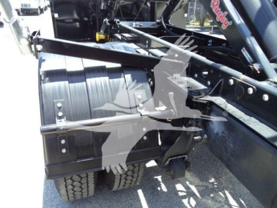 [Component] [View] showing attachable roll-off container and hydraulic framework with chain links and mounting bolts, and tires in the background.