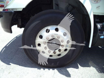 Truck wheel and tire assembly on a 2020 International MV rolloff showing front wheel with silver hub and lug nuts.