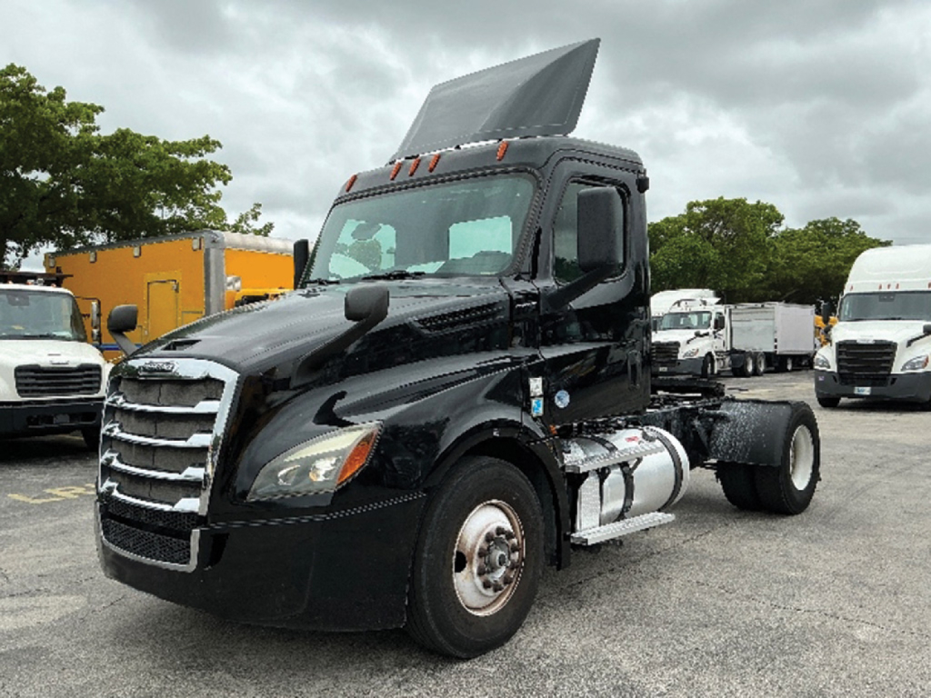 Freightliner Cascadia126 truck cab with lowered hood showing front grille and side fuel tanks. Visible text includes nothing legible on the truck itself.