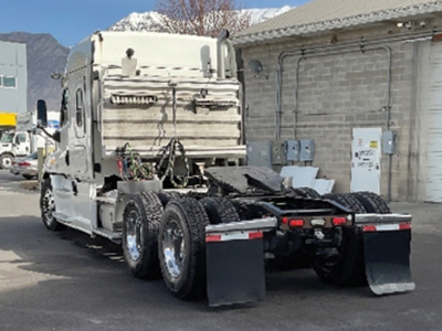 Conventional sleeper Freightliner Cascadia125 tractor rear view showing fifth wheel, dual rear axles, mud flaps, and chassis components.