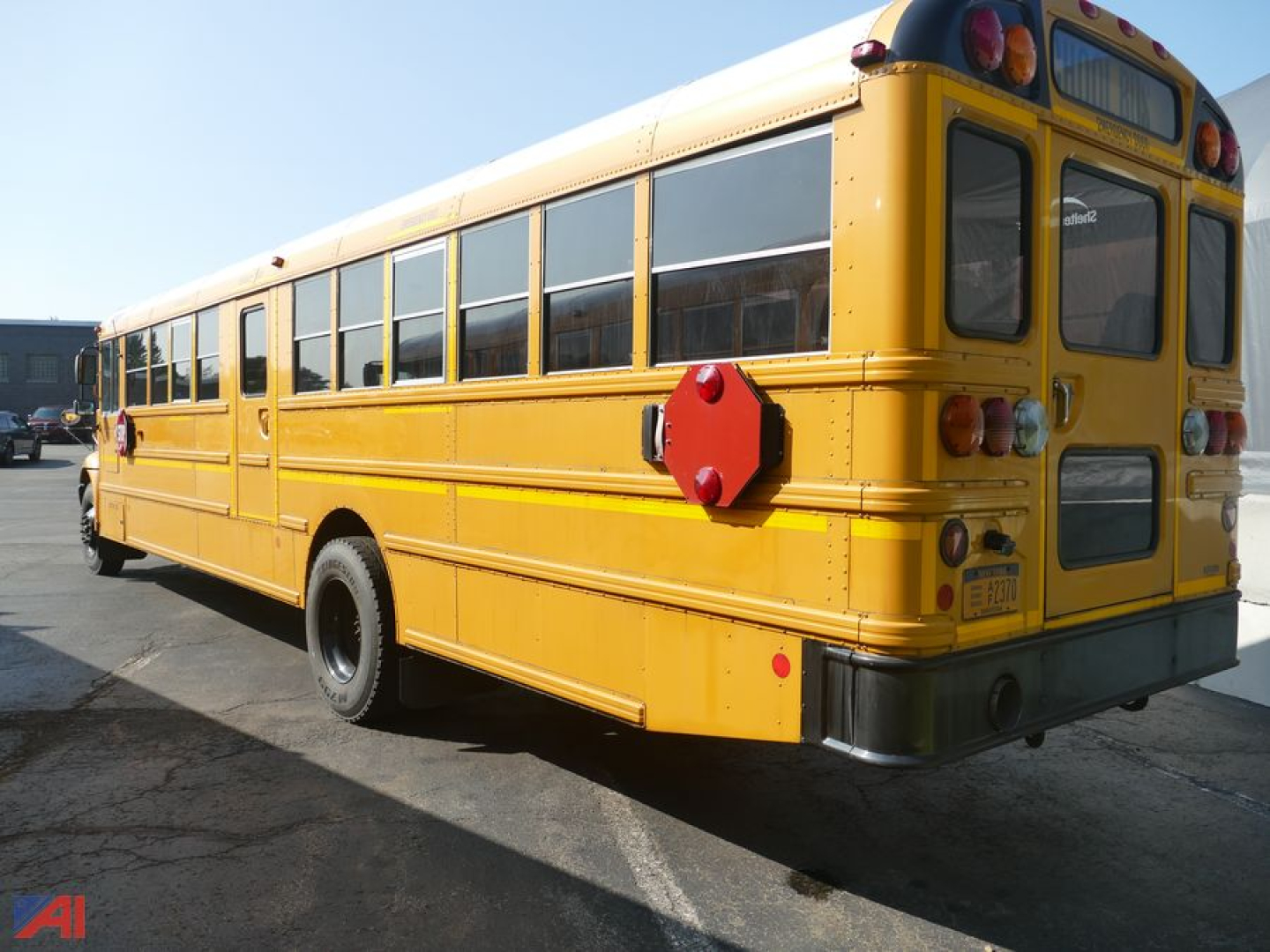 Yellow IC Corporation CE 3000 school bus rear view showing red emergency exit hatch and rear window with taillights.