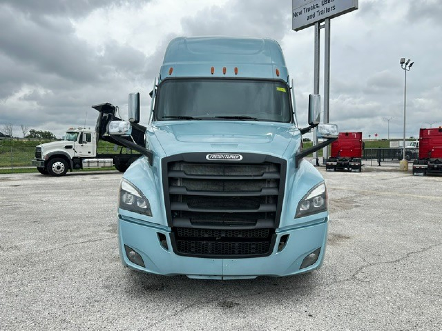 Front view of a light blue 2023 Freightliner Cascadia 126 tractor with large black grille, headlights, and side mirrors visible.
