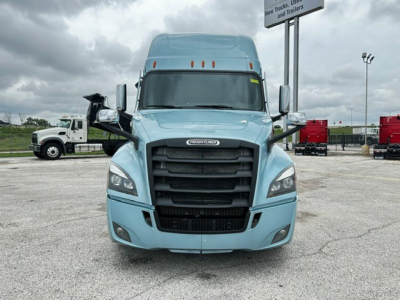 Front view of a light blue 2023 Freightliner Cascadia 126 tractor with large black grille, headlights, and side mirrors visible.