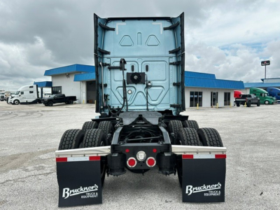 Rear view of a Freightliner Cascadia 126 tractor showing dual rear axles, mud flaps with Bruckner's logo, and trailer hookup components.