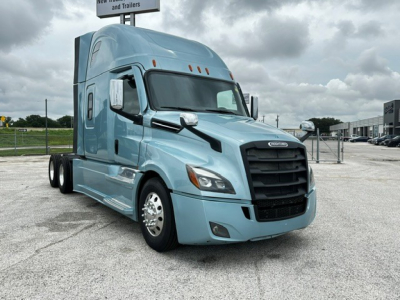 Freightliner Cascadia 126 tractor profile in blue, front-left view, with black grille and dual wheels, daytime overcast sky.