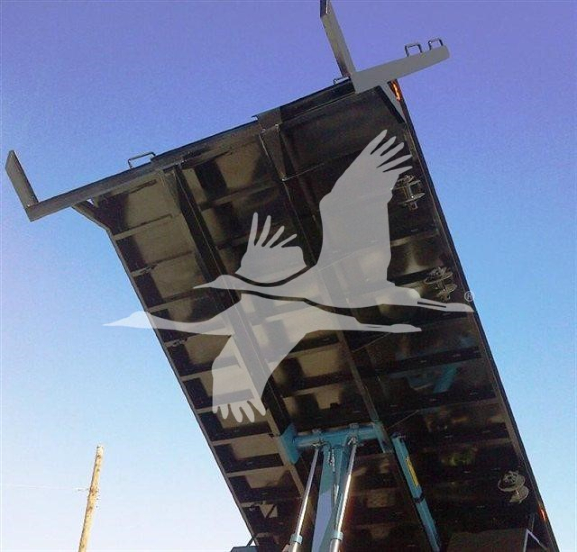 Flatbed truck bed raised at an angle with a white bird graphic; underside and hydraulic supports visible.