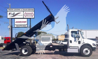 Flatbed tow truck with extended dump body showing 20 ft bed and hydraulic hoist, TLC Advanced Fabricators sign in background.