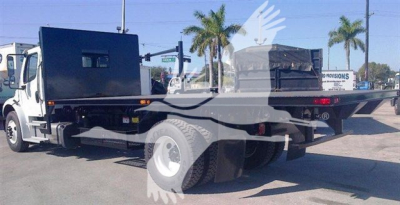 Flatbed truck rear/side view showing flatbed, dual rear tires, and storage box on the bed; no legible model or branding text visible.