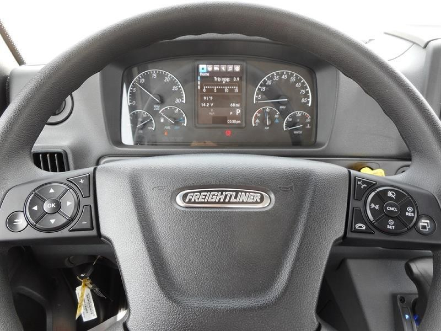 Freightliner M2 106 dash and steering wheel showing instrument cluster and controls.