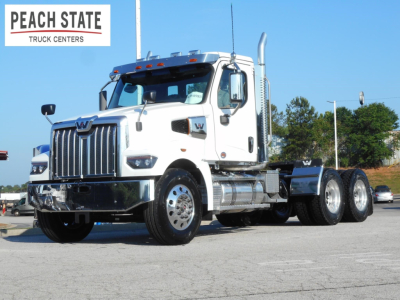 Western Star 49X Day Cab truck in white front-side view showing chrome bumper, large grille, dual rear axles, and Peach State Truck Centers logo in upper left.