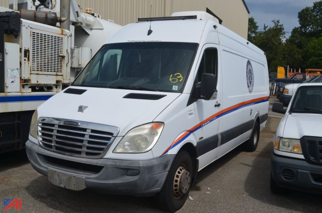 Visible: 2012 Freightliner Sprinter van for video inspection, white cargo van with orange/blue side stripe, front grille, and side badge.