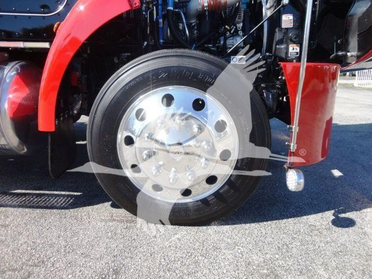 Peterbilt 337 truck front wheel and fender area showing chrome hub and black tire.