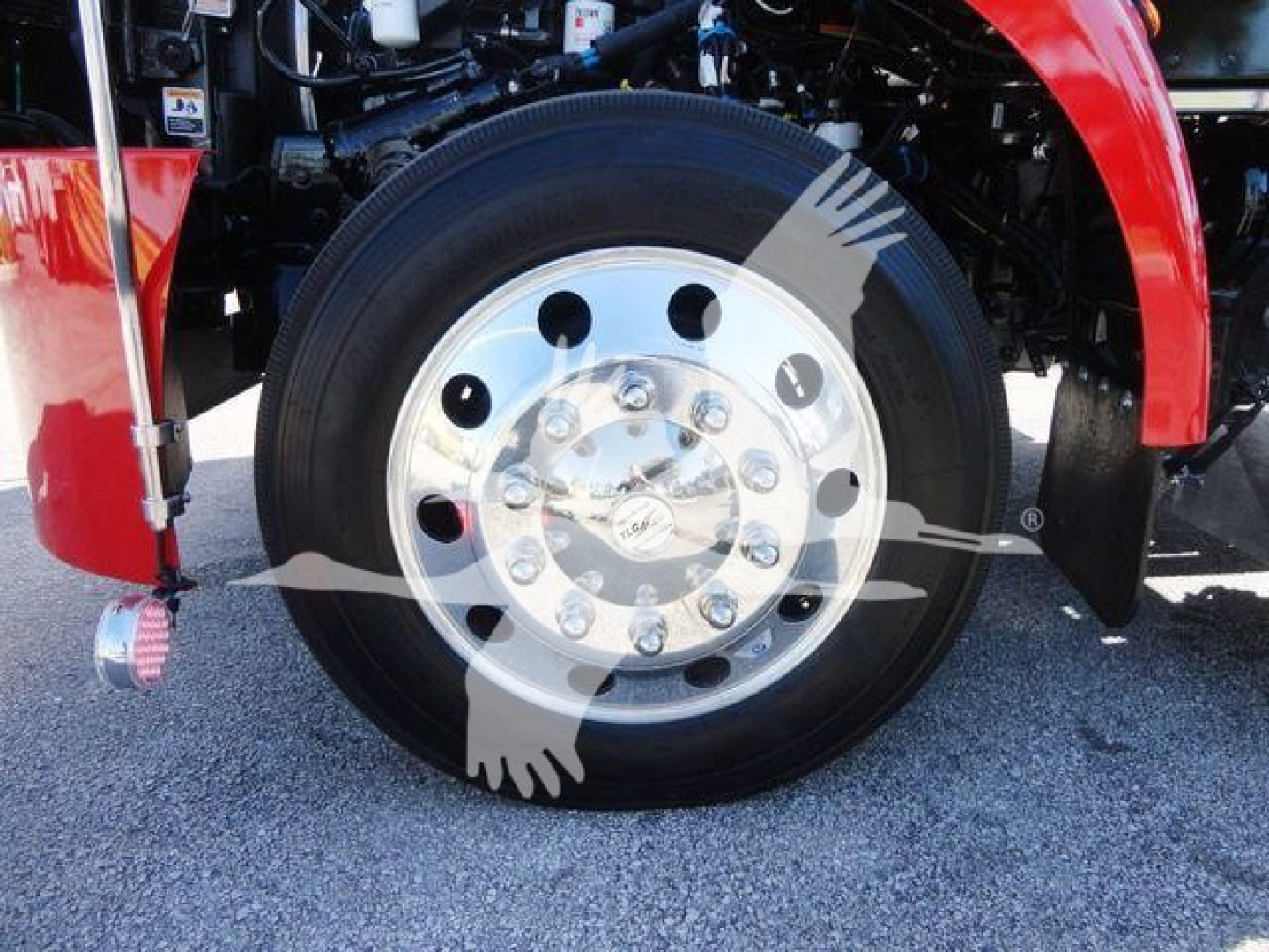 Peterbilt 337 wheel and front fender showing front wheel with hub and lug nuts; red body panel and wheel well visible.