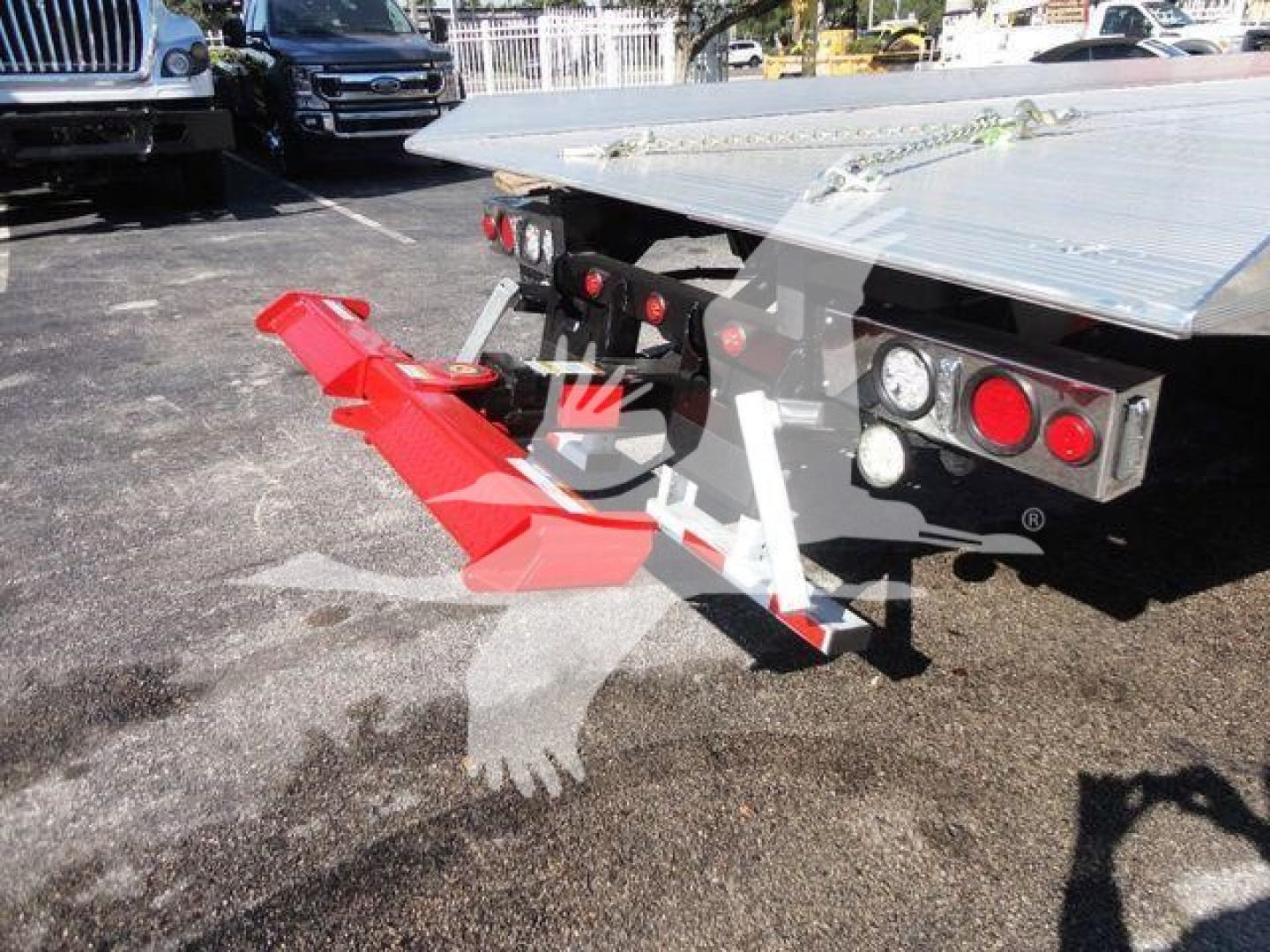 Vehicle hitch or rollback component mounted to a 2022 Peterbilt 337 truck bed showing red hitch attachment and rear lights