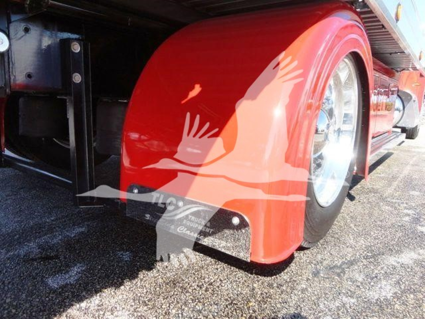 Peterbilt 337 rollback truck side view showing red fender and wheel, part of the chassis visible.