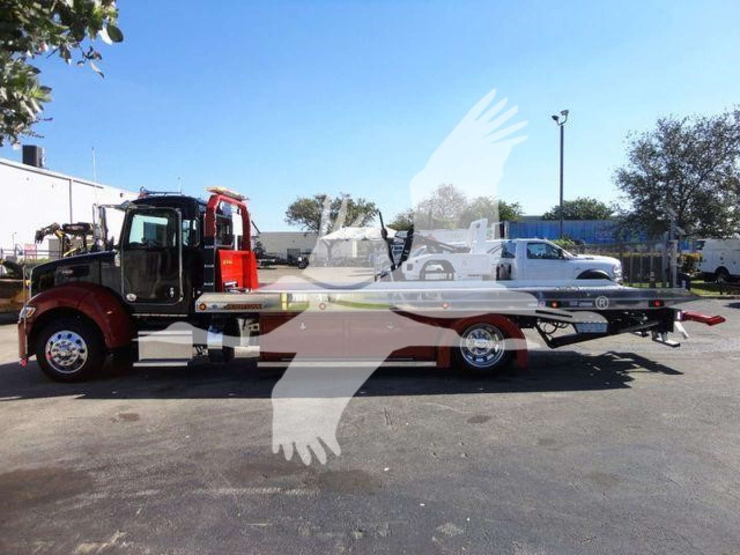 Peterbilt 337 rollback truck in new condition, side view showing flatbed with wheel lift and hydraulic ramps, stock J04652.