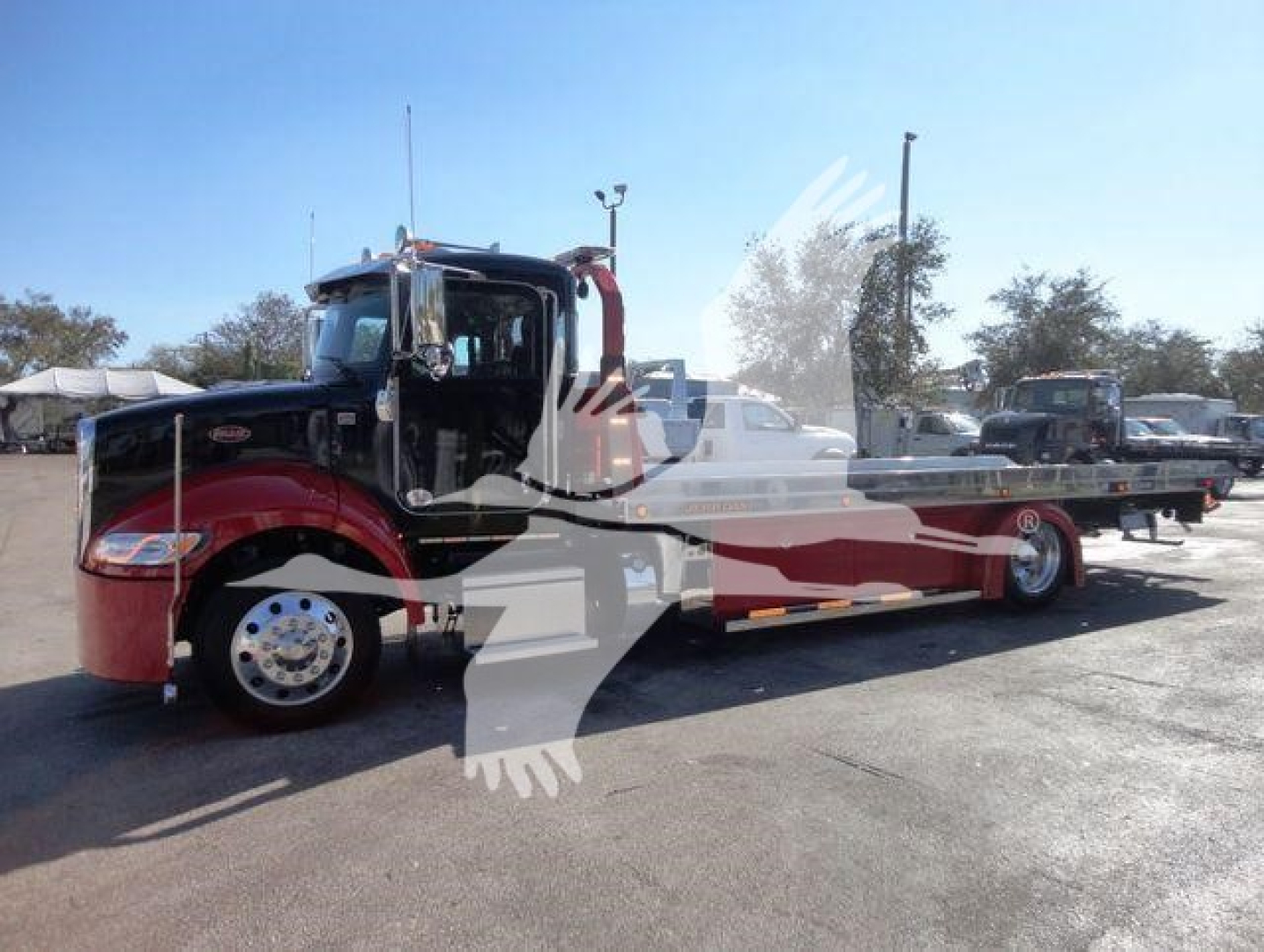 Peterbilt 337 rollback truck in red and black livery with long wheelbase and flatbed.