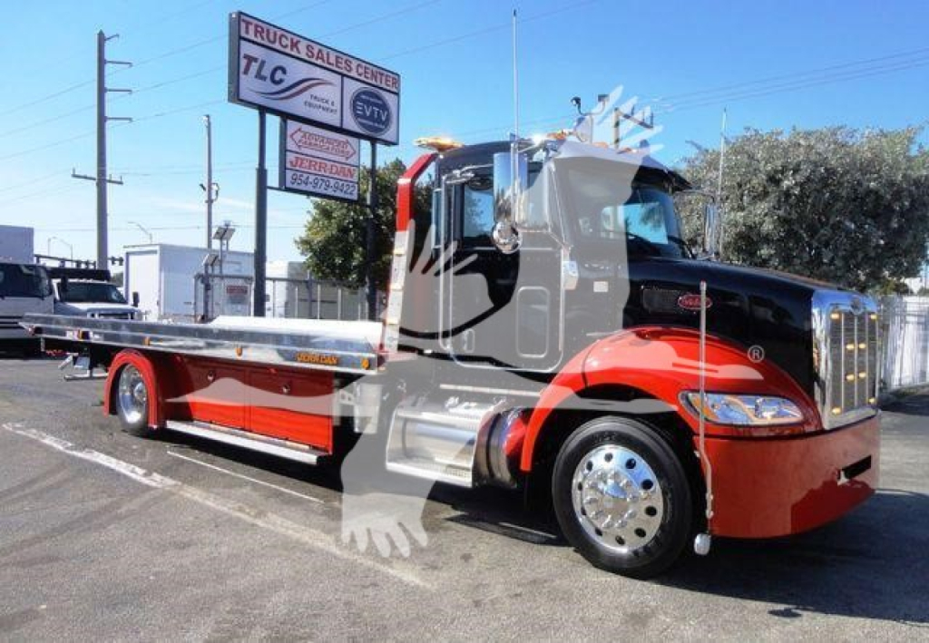 Peterbilt 337 rollback tow truck in red and black with flatbed, dealership sign in background, stock number J04652.