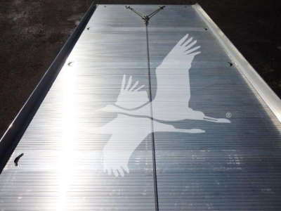 Flatbed trailer or ramp surface with a large bird graphic in white on metal surface.