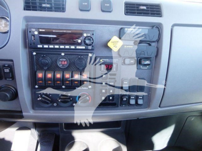 Peterbilt 337 dash cluster with radio, climate controls, and switches; visible labels include CD/Radio unit, knobs, and warning tag shapes on the panel.