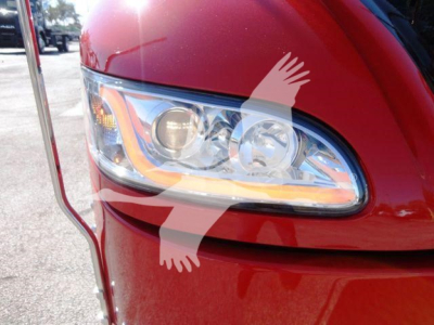 Peterbilt 337 headlight area on a red truck, front fender and side mirror visible.